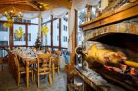 a dining room with a fireplace and a table with chairs at ЗАМЪКА 1 in Pamporovo