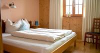 a bedroom with a bed with white sheets and a window at Bio Ferienbauernhof Greber in Schwarzenberg