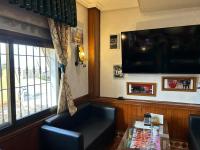 ein Wohnzimmer mit Sofa und Flachbildfernseher in der Unterkunft Hostal Restaurante La Noria in Arquillos