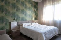 a bedroom with a bed with a green leafy wall at Suite Dall'Alba al Tramonto in Mogliano Veneto