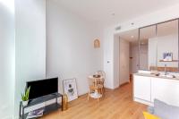 a living room with a tv and a kitchen at Les Appartements de Grenoble in Grenoble