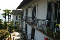 an apartment building with balconies and tables and chairs at Hotel Villa Ruscello in Baveno
