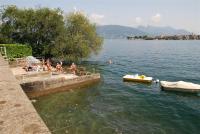 a group of people sitting on a dock in the water at Hotel Villa Ruscello in Baveno