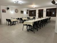 comedor con mesas y sillas y reloj en Hôtel Comme chez soi, en Jas