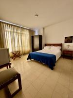 Un dormitorio con una cama grande con una manta azul. en HOTEL ARMENIA CENTRO , Tenemos AGUA CALIENTE , Gracias, en Armenia