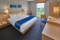 Un dormitorio con una cama y un escritorio y una ventana. en City Express by Marriott Culiacan, en Culiacán