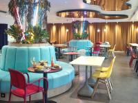 un restaurante con mesas y sillas coloridas en una habitación en B&amp;B HOTEL Paris 17 Batignolles, en París