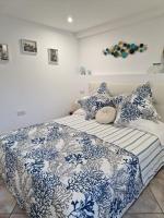 Cama con sábanas y almohadas azules y blancas en Casetta Milù, en Anacapri