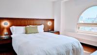 a bedroom with a large white bed with a window at Hub Hotel Kaohsiung Cisian Branch in Kaohsiung