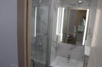 a bathroom with a shower and a sink and a mirror at Geographotel Paris-Roissy CDG Airport in Le Mesnil-Amelot