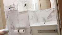 a white bathroom with a sink and a mirror at Geographotel Paris-Roissy CDG Airport in Le Mesnil-Amelot