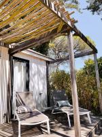 two chairs and a pergola on a wooden deck at Le Phare in Les Portes