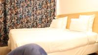 a hotel room with a bed with white sheets at Geographotel Paris-Roissy CDG Airport in Le Mesnil-Amelot