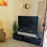 a flat screen tv sitting on top of a black entertainment center at Villa Red Palmer -sauna jacuzzi in Gros-Morne