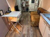 a kitchen and living room with a table and a couch at La Tiny : Adorable petit studio &#47;parking gratuit. in Angoulême