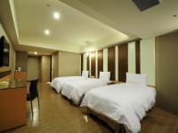 a hotel room with two beds with white sheets at Goodness Plaza Hotel in Taishan