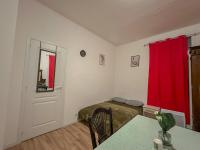 a bedroom with a bed and a red curtain at Charmant Studio avec Balcon in Perpignan