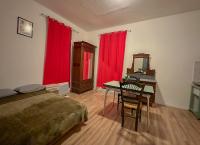 a bedroom with a bed and a desk and red curtains at Charmant Studio avec Balcon in Perpignan