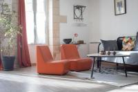 2 sillas naranjas y una mesa en la sala de estar en Appartement Les Cyprès de l’Île, en Aviñón
