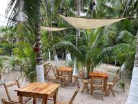 エル・コージョにあるCasa Balooのヤシの木のあるビーチに置かれたテーブルと椅子のグループ