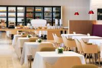 Un comedor con mesas y sillas blancas. en SEAMARQ HOTEL, en Gangneung