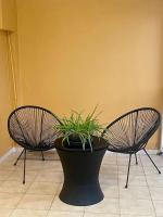 3 Stühle und eine Topfpflanze in einem Raum in der Unterkunft Myosotis, charmant logement central avec piscine privée, wifi et parking gratuit in Petit-Bourg