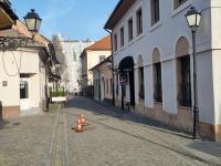 an empty street with traffic cones on a cobblestone street at Garage studio in Bistriţa