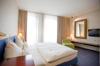 Una habitación de hotel con una cama grande y un espejo. en Hotel Lehmeier, en Neumarkt in der Oberpfalz