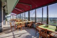 Un restaurante con mesas y sillas y grandes ventanales. en Eco complex Zdravets near Varna, en Zdravets