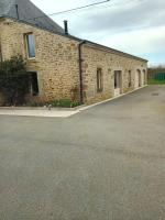 a brick building with a parking lot in front of it at Domaine de kerbillec in Theix
