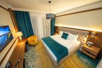 Habitación de hotel con cama y TV en Grand Hotel Belushi, en Boge