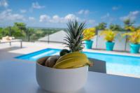 a bowl of fruit sitting next to a pool at Tropic &amp; Chic in Sainte-Anne