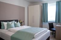 a bedroom with a large bed with a chair and a window at Hotel Claro Garni in Eitting