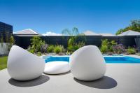 two white chairs sitting next to a swimming pool at Tropic &amp; Chic in Sainte-Anne