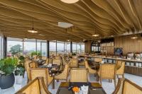 un restaurant avec des tables, des chaises et des fenêtres dans l'établissement Florence Hotel, à Đà Nẵng