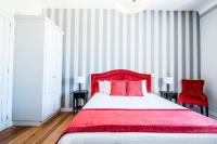 a bedroom with a red bed and two red chairs at Gîte Château de Seguin in Lignan-de-Bordeaux