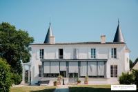 a large white house with two spires at Gîte Château de Seguin in Lignan-de-Bordeaux