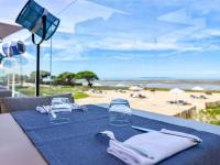 - une table bleue avec des verres et une vue sur la plage dans l&#39;établissement La Grande Terrasse Hotel&amp;Spa La Rochelle MGallery Hotel Collection, à Châtelaillon-Plage