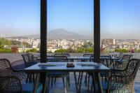 Una vista de una ciudad desde un restaurante con mesas y sillas. en Palace Catania | UNA Esperienze, en Catania