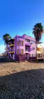 a purple building with palm trees in front of it at OpenSky in São Filipe
