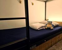 a teddy bear sitting on top of a bed at Meeting Mates Hostel in Taipei