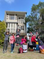 a group of people jumping in the air in front of a house at I Leisure B&amp;B in Yuanshan