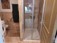 a shower with a glass door in a bathroom at maison luxe cléo aeroport tillé 4 a 5 personnes in Tillé