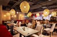 a restaurant with tables and chairs and lights at Amedia Linz, Trademark Collection by Wyndham in Linz