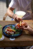 a person holding a plate of food on a table at LOLA Boutique Hôtel - Bordeaux Centre in Bordeaux