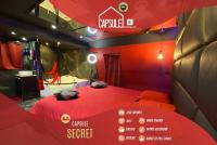 a room with a red bed in a room with a bathroom at Capsule Secret - Jacuzzi - Netflix &amp; Home cinéma - Jeux de couple - Barre de pole dance in Valenciennes