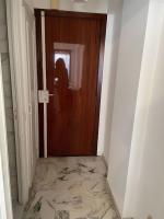 a woman standing in front of a door with a marble floor at Studio 50 m de la mer - Centre - Vue mer partielle in Nice