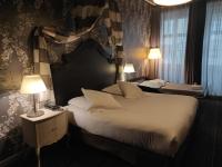 a hotel room with a large bed and two lamps at Hôtel de Paris in Besançon