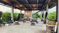a pavilion with picnic tables and barrels and trees at Kitefarm in Dongshan