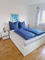 Una cama con almohadas azules en un dormitorio en Panorama Apart Bad Säckingen, en Bad Säckingen
